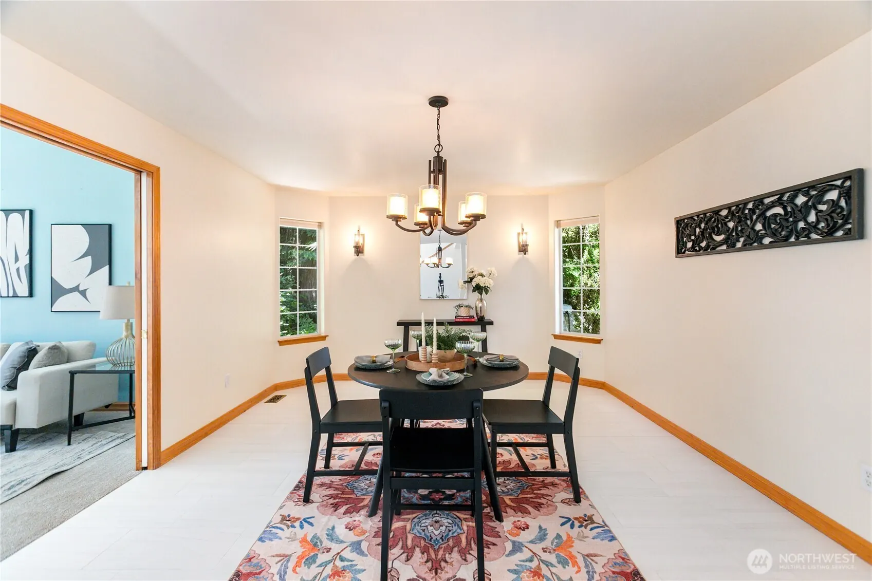 Formal dining room with a dark wood table, patterned rug and chandelier.